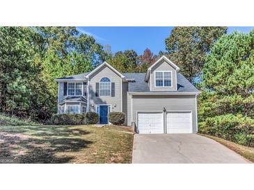 Charming two-story home featuring a two-car garage, complemented by a well-maintained lawn and mature trees at 3130 Lower Creek Dr, Douglasville, GA 30135
