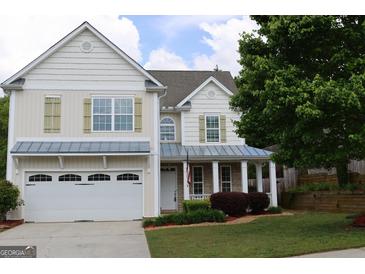Charming two-story home with neutral siding, attached garage and well-manicured landscaping at 507 Rippling Dr, Temple, GA 30179