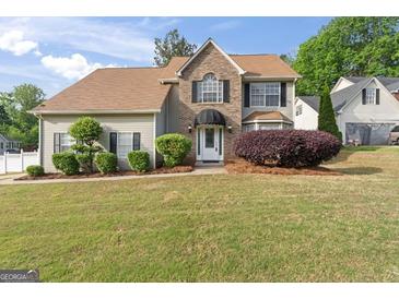 Charming home featuring a well-manicured lawn and a mix of brick and vinyl siding at 3941 Kings Pl, Ellenwood, GA 30294