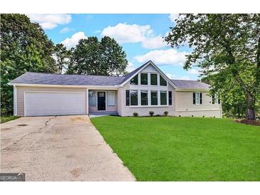 Charming single-story home with a well-maintained lawn, a two-car garage and a beautiful window design at 4397 Bluebird Ln, Lithia Springs, GA 30122