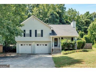 Charming two-story home with a two-car garage and a well-manicured lawn at 127 Muirwood Dr, Temple, GA 30179