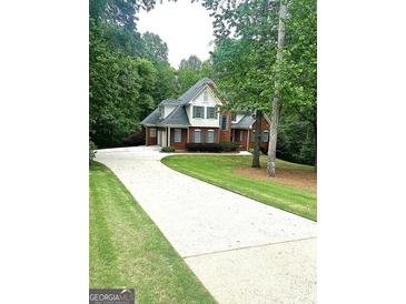 Charming two-story brick home featuring a long driveway and lush landscaping at 340 Antebellum Way, Fayetteville, GA 30215
