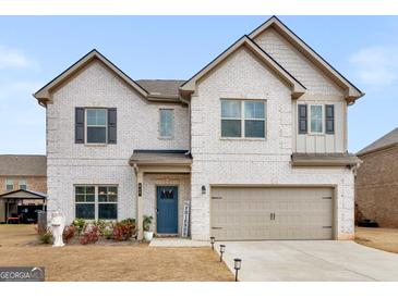 Charming two-story white brick home with a well-manicured lawn, perfect for a growing Gathering at 445 Sawmill Trce, Hampton, GA 30228