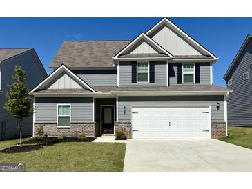 Charming two-story home with a gray exterior, two-car garage, well-maintained lawn, and beautiful brick accents at 438 Prescott Way, Villa Rica, GA 30180
