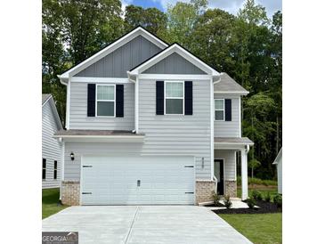 Charming two-story home boasts a modern facade, a spacious garage, and manicured landscaping at 439 Prescott Way, Villa Rica, GA 30180