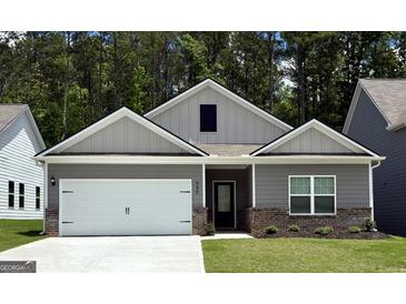 Charming single-story home featuring a white garage door and gray siding, complete with a well-manicured lawn at 445 Prescott Way, Villa Rica, GA 30180