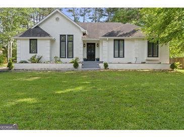 Charming single-story home with manicured lawn and classic black trimmed windows at 1291 Interlaken Pass, Jonesboro, GA 30238