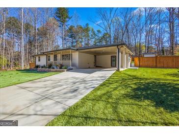 Charming brick home featuring a covered carport, well-manicured lawn, and inviting curb appeal at 5109 Dogwood Hills Dr, Sugar Hill, GA 30518