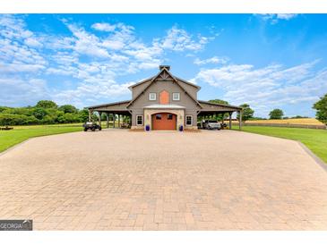 Stunning exterior view of barn with covered parking and large driveway with brick pavers at 290 Weldon Rd, Fayetteville, GA 30215
