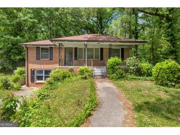 Brick home with a covered front porch and landscaped yard at 2531 Hood Nw Ave, Atlanta, GA 30318