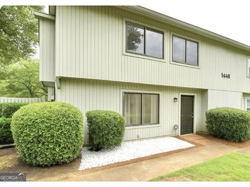 Charming townhome featuring a well-manicured lawn and tidy landscaping with an inviting facade at 1448 Pine Log Ne Rd # C, Conyers, GA 30012