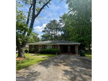 Charming brick ranch home with a well-maintained lawn and covered parking area at 9163 Fair Sw St, Covington, GA 30014