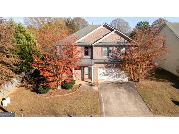 Charming two-story brick home featuring a well-maintained lawn and mature trees at 1281 Heartwood Ave, Mcdonough, GA 30253