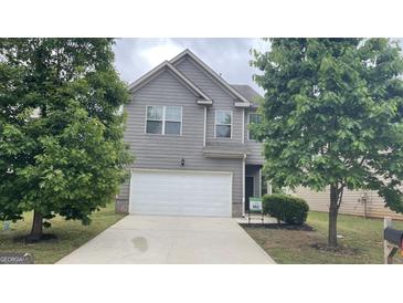 Charming two-story home with gray siding, a two-car garage, and a well-maintained front yard at 1392 Worcester Trl, Mcdonough, GA 30253