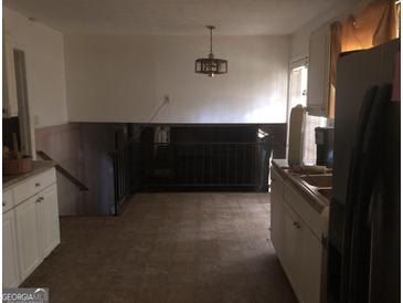 Bright kitchen with white cabinets, tile floor, and a view of the lower level at 2017 Pine Cone Sw Dr, Atlanta, GA 30331