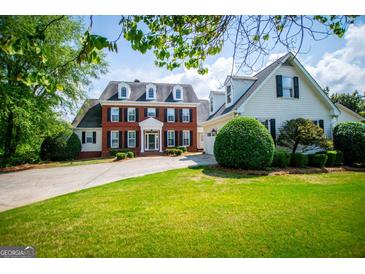 Charming two-story brick home featuring a well-manicured lawn and a circular driveway, enhancing its curb appeal at 1745 Stripling Chapel Rd, Carrollton, GA 30116