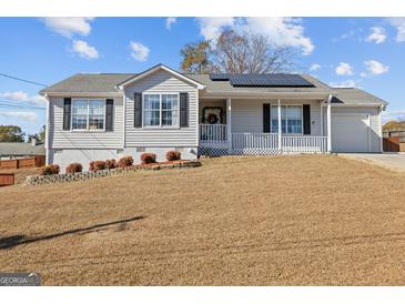 Charming one-story home featuring a cozy front porch, well-maintained landscaping, and a two-car garage at 6324 Amberly Rd, Rex, GA 30273
