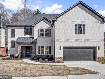 Beautiful two-story home featuring white brick, black shutters, and an attached two-car garage at 209 Langshire Dr, Mcdonough, GA 30253