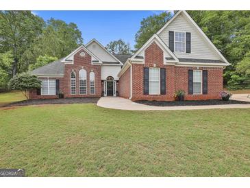 Charming brick home with manicured lawn and mature trees offers classic curb appeal at 215 Murphy Creek Ln, Fayetteville, GA 30215