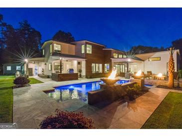 Stunning backyard pool area with fire bowls and outdoor kitchen, perfect for entertaining at 159 Sims Rd, Tyrone, GA 30290