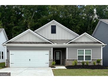 Charming single-story home featuring a two-car garage, a well-manicured lawn, and elegant landscaping at 435 Prescott Way, Villa Rica, GA 30180