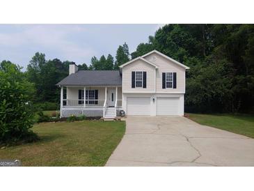 Charming two-story home with a two car garage, covered porch, and well-maintained lawn at 2477 Briar Valley Way, Dacula, GA 30019