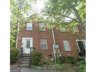 Brick townhouse with red shutters, white trim and a small front stoop surrounded by green foliage at 3191 Kingswood Gln, Decatur, GA 30034