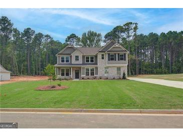 Inviting two-story home featuring a well-manicured lawn, neutral color scheme, and complementary landscaping at 100 Bre Dr, Fayetteville, GA 30214