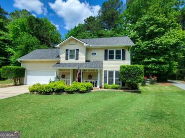 Charming two-story home boasts a well-manicured lawn, a welcoming porch, and lush greenery, creating delightful curb appeal at 508 Caxton Ct, Peachtree City, GA 30269