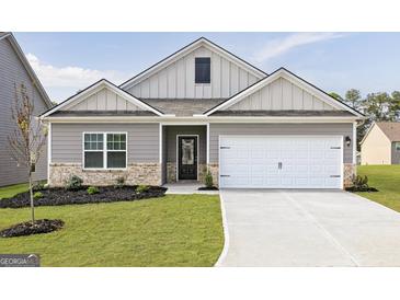 Charming home featuring a two-car garage, tasteful brick accents, and a well-manicured lawn at 281 Limestone Circle, Conyers, GA 30013