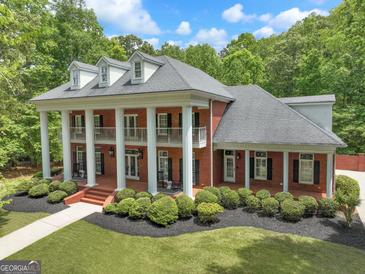 Stunning two-story brick home featuring a columned front porch and beautifully landscaped front yard at 602 Embassy Ct, Peachtree City, GA 30269