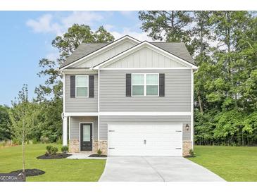 Charming two-story home features gray siding, black shutters, and an attached two-car garage at 315 Limestone Circle, Conyers, GA 30013