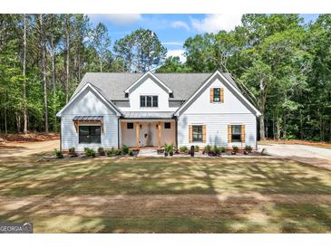 Stunning new construction features a modern farmhouse exterior with stylish wood-look shutters and a meticulously manicured front yard at 4731 H D Atha Rd, Covington, GA 30014