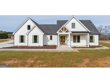 Charming white farmhouse with black roof, green shutters, and lovely landscaping at 4751 H D Atha Rd, Covington, GA 30014