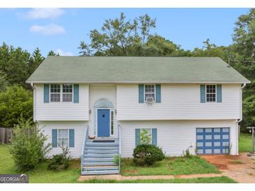 Charming two-story home with blue door, light-colored siding, and a green shingled roof at 140 Joshua St, Palmetto, GA 30268