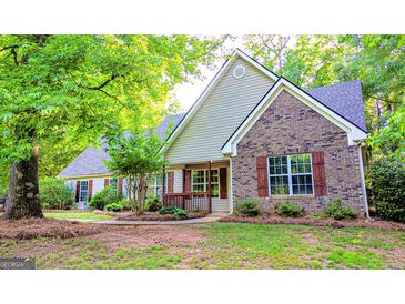 Charming single-Gathering home featuring brick and siding exterior, complemented by lush landscaping and mature trees at 530 Austin Dr, Mcdonough, GA 30252