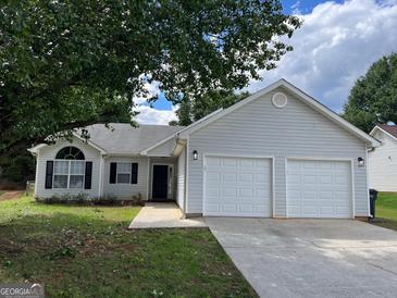 Charming single-story home featuring a two-car garage, tidy landscaping, and a welcoming entrance at 3081 Regal Dr, Mcdonough, GA 30253