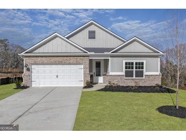 Charming one-story home with brick and gray siding, well-manicured lawn, and a two-car garage at 3382 Arabian Farm Ln, Dacula, GA 30019
