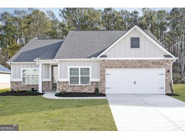 Charming single-Gathering home boasting a brick and siding facade, manicured lawn, and attached two-car garage at 3734 Saddle Bag Ct, Dacula, GA 30019