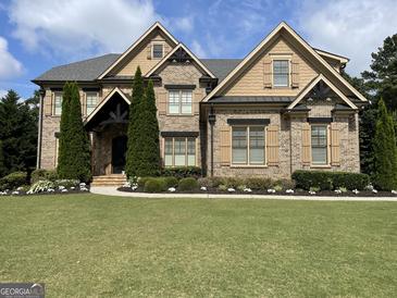 Stunning two-story brick home with manicured lawn and beautiful landscaping, creating an inviting curb appeal at 2220 Cambridge Hill Ct, Dacula, GA 30019