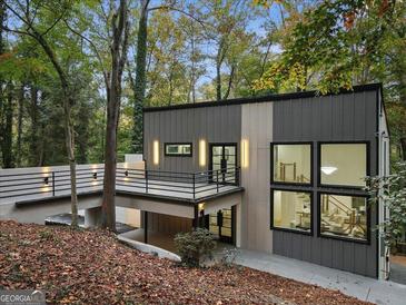 Modern home with gray siding, stylish lighting, balcony, and large windows offering abundant natural light at 1153 Dawn View Nw Ln, Atlanta, GA 30327