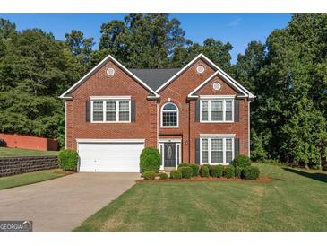 Beautiful two-story brick home with a manicured lawn and attached two-car garage at 440 Homeplace Dr, Stockbridge, GA 30281