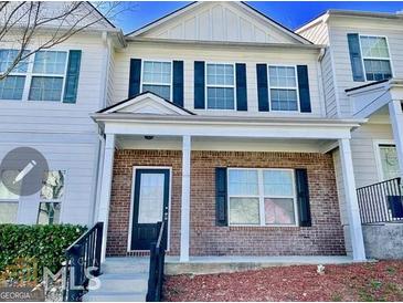 Charming two-story townhouse with a brick facade, black shutters, and a covered front porch at 6206 Flat Trace, South Fulton, GA 30291
