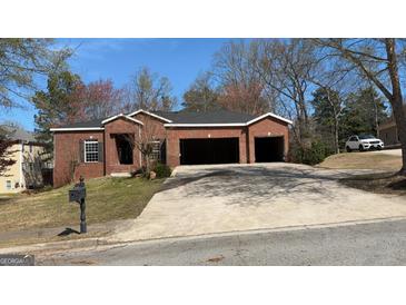 Charming brick home featuring a two-car garage and well-maintained lawn at 8828 Patricia Rose, Douglasville, GA 30134