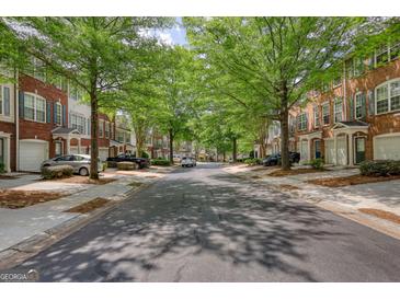 Charming street view of brick townhomes with mature trees lining the street, creating a welcoming atmosphere at 2160 Dillard Xing, Tucker, GA 30084