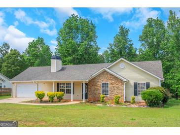 Charming single-story home with a stone accent wall and a well-manicured front yard at 90 Heatherstone Way, Covington, GA 30016