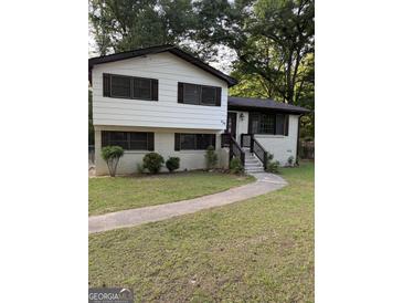 Charming two-story home with white and brown trim and a well-maintained front yard at 554 Windsor Dr, Forest Park, GA 30297
