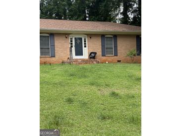 Charming brick home with well-manicured lawn and welcoming front porch, creating an inviting curb appeal at 2903 Revere Ct, East Point, GA 30344