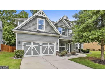 Inviting gray two-story home featuring a two car garage, gray shake siding, and manicured lawn at 70 Pacific Ave, Sharpsburg, GA 30277