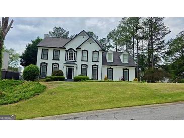 Classic two-story home boasting a well-manicured lawn and charming architectural details at 303 Sedgewick Trl, Lawrenceville, GA 30044